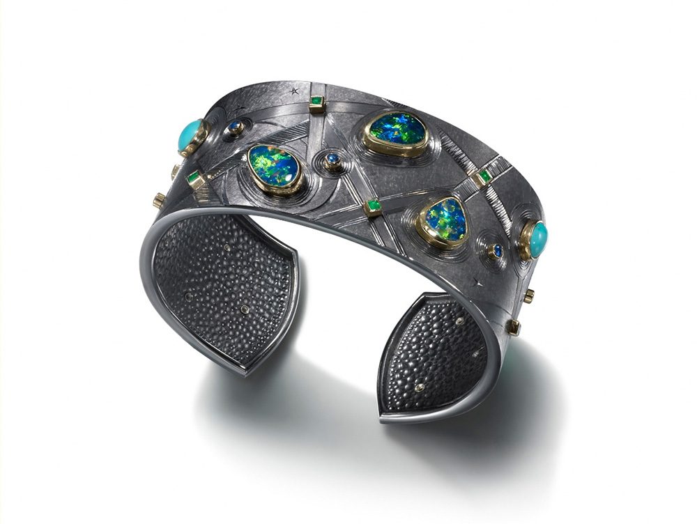 <a href="/jewellery/black-cuff-cuff-silver-finished-black-rhodium-hand-engraved-set-opals-turquoise-emeralds">Black Cuff CUFF Silver finished in Black Rhodium.  Hand engraved, set with Opals, Turquoise, Emeralds and Sapphires. Approx. 7 cm across Made 2012. Photo : Simon B Armitt</a>