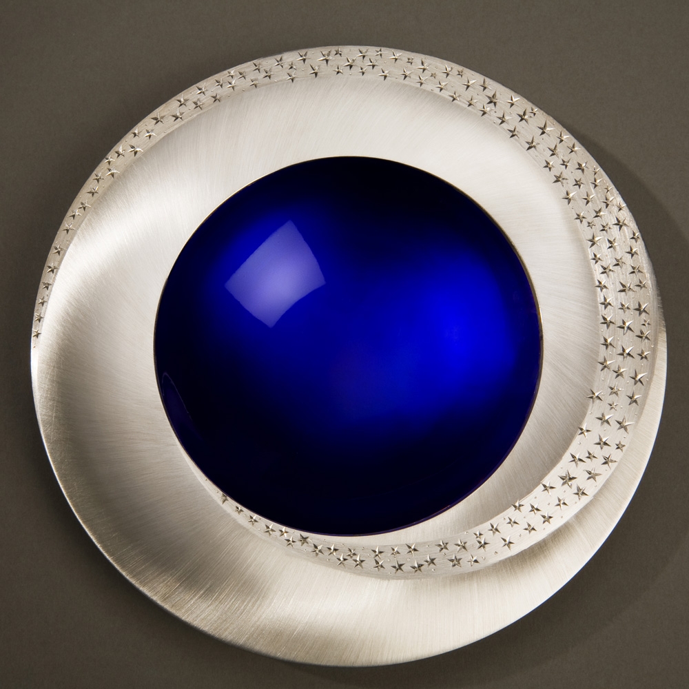 <a href="/jewellery/starlight-bowl-150-mm-diameter-britannia-silver-blue-enamel-hand-engraved-brushed-and">STARLIGHT BOWL 150 mm diameter. Britannia Silver. Blue Enamel, Hand Engraved. Brushed and striated finish. Base polished Limestone. Bowl is designed to spin gently on its stone base. Photo : Simon Armitt</a>